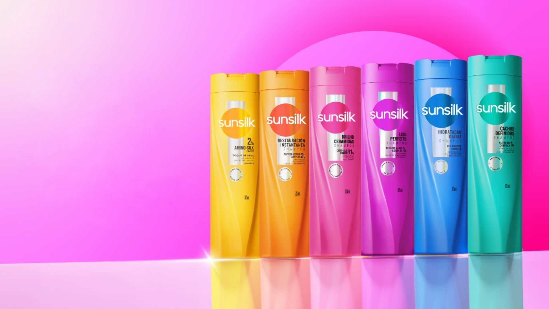 Enam botol sampo Sunsilk dengan kemasan warna-warni berlatar belakang merah muda. Sunsilk adalah salah satu merek Beauty & Wellbeing Unilever.