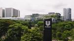 Bangunan modern dengan papan nama Unilever yang dikelilingi pepohonan.