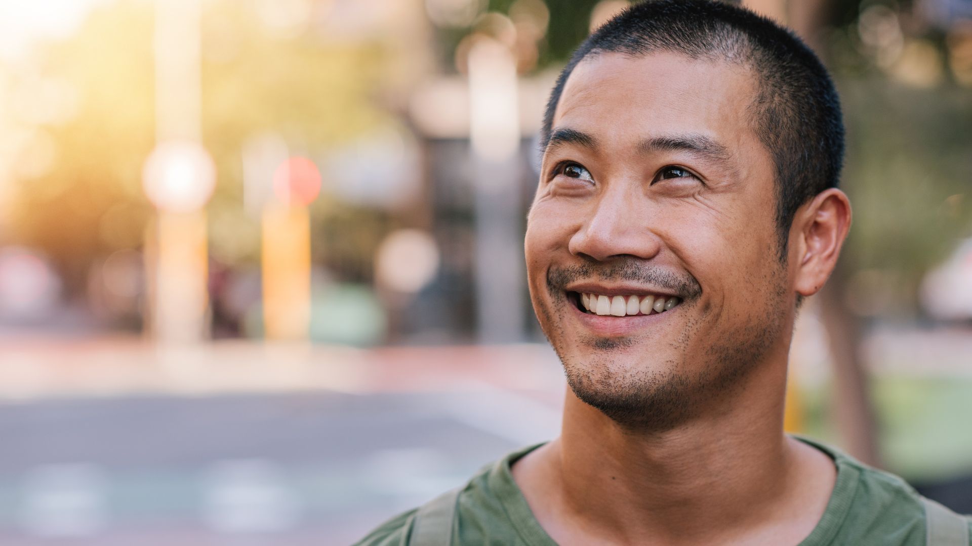 Orang yang tersenyum di luar ruangan pada hari yang cerah.